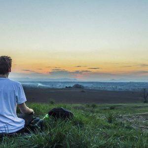 Mann meditiert auf einem Hügel