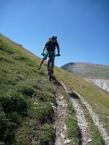 Mann fährt Berg runter mit Mountainbike