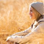 Glückliche Frau sitzt in Dünen