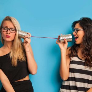 Zwei Frauen streiten mit einem Dosentelefon