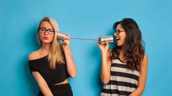 Zwei Frauen streiten mit einem Dosentelefon