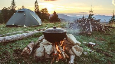 Camping mit Zelt und Lagerfeuer