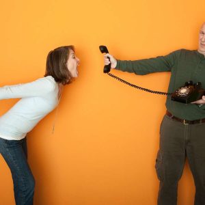 Gestresste Frau schreit in Telefonhörer