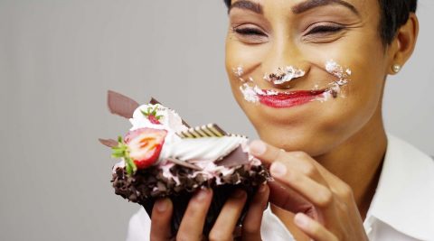 Frau isst Schokokuchen und ist glücklich