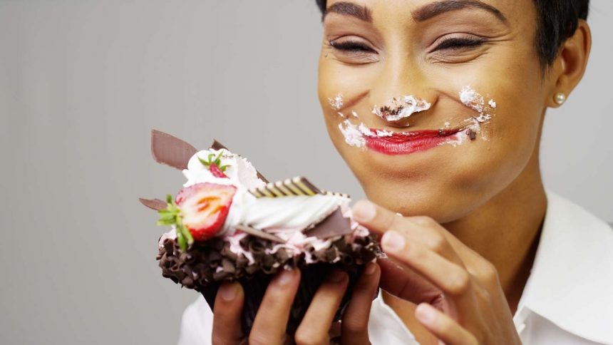 Frau isst Schokokuchen und ist glücklich