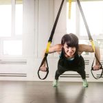 Eine Frau trainiert mit dem TRX