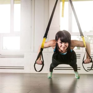 Eine Frau trainiert mit dem TRX