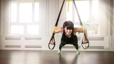 Eine Frau trainiert mit dem TRX