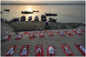 Yogis in Savasana (Totenstellung) an den heiligen Ghats von Varanasi