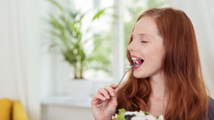 Frau isst gesunden Salat: Abnehmen mit Rohkost
