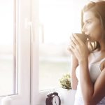 Eine Frau trinkt ein heißes Getränk zum Wachwerden am Morgen