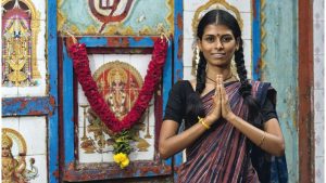 Lakshmi Dhanaraj vor einem Wandbild des Hindugottes Ganesha 