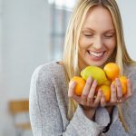 Eine Frau mit Zitrusfrüchten: Sauer statt süß gegen Zuckersucht