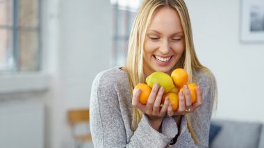 Eine Frau mit Zitrusfrüchten: Sauer statt süß gegen Zuckersucht