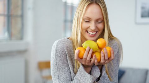 Eine Frau mit Zitrusfrüchten: Sauer statt süß gegen Zuckersucht