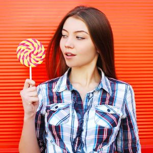 Frau mit Süßem: Anzeichen, dass du zu viel Zucker isst