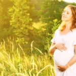 Glückliche schwangere Frau in der Natur