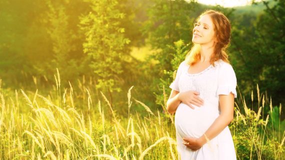 Glückliche schwangere Frau in der Natur