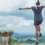Junge Frau springt frei und leidenschaftlich über eine Mauer