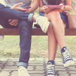Mann und Frau nutzen ein Smartphone statt zu reden: Smartphone-Sucht
