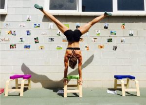 Lucie Beyer übt Handstand auf dem Kopfstandstuhl