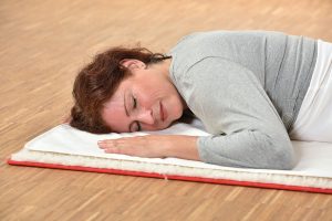 Frau schläft auf Yogatuch