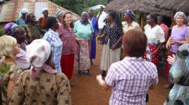Frauen in Kenia vor Lehmhütten