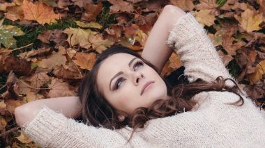 Junge Frau liegt entspannt im Laub