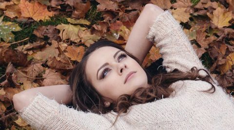 Junge Frau liegt entspannt im Laub