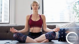 Junge Frau meditiert mit Kopfhörern