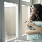Glückliche Frau hält ein Kissen vor den Bauch