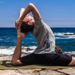 Mann macht Yoga am Strand