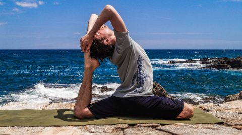 Mann macht Yoga am Strand