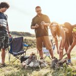 Freunde bereiten beim Campen ihr Abendessen zu