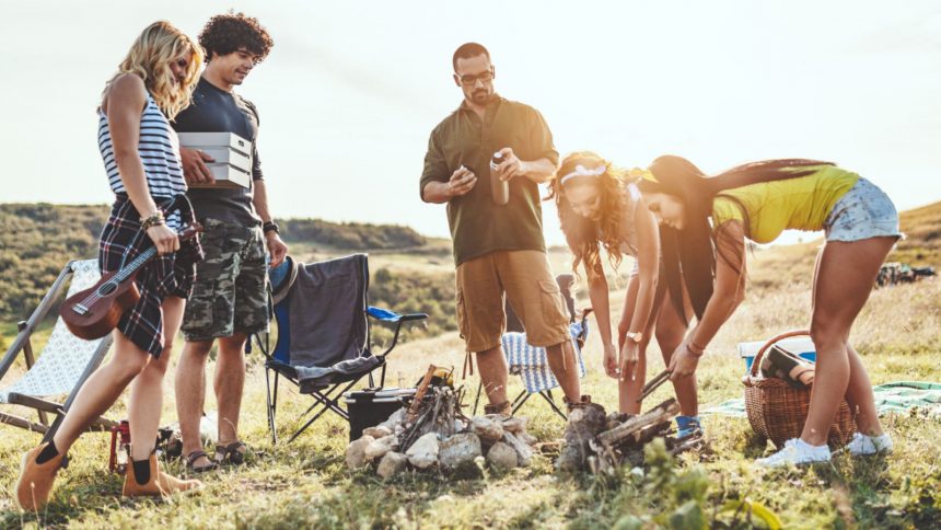 Freunde bereiten beim Campen ihr Abendessen zu