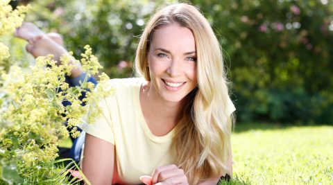 Frau liegt im Garten in der Sonne