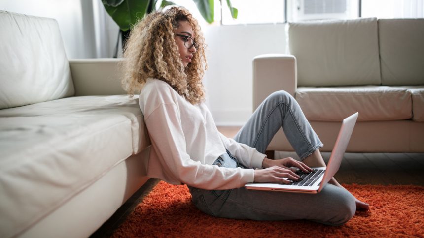 Junge Frau arbeitet mir ihrem Laptop zuhause